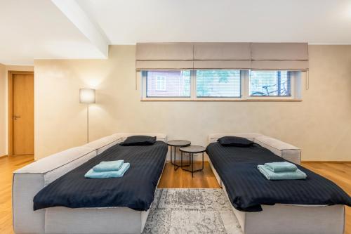 塔尔图Gustav Apartments - City Center Comfort的一间卧室配有两张床和一张桌子