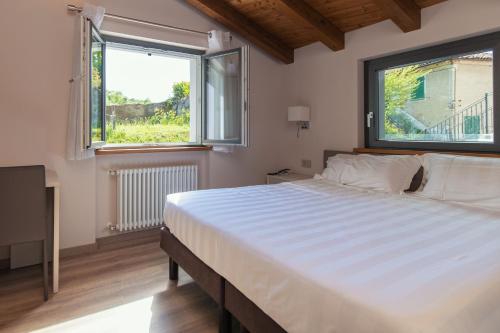 CarcareEr Mirin - Il Mulino di Carcare Hotel的一间卧室设有一张大床和两个窗户。