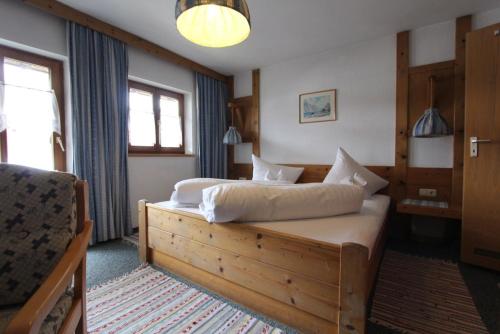因泽尔Gästehaus Inzeller Hof的一间卧室配有一张带白色床单的大床