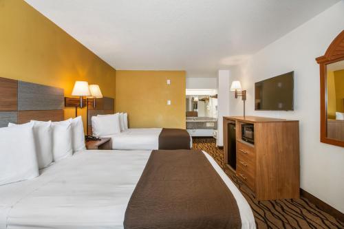 加尔维斯敦Motel 6 Galveston, TX Seawall的酒店客房设有两张床和一台平面电视。