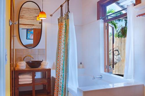 基韦斯特Key West Bed and Breakfast的带浴缸、水槽和镜子的浴室