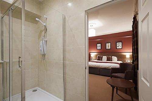 多诺赫鹰酒店的带淋浴的浴室和1间带1张床的卧室