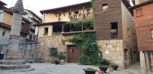 Valverde de la VeraCasa Rural La Picota的一座常春藤生长在它的一侧的建筑