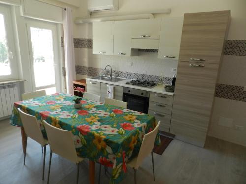 佩鲁贾Appartamenti Via Cortonese 1的厨房配有一张桌子,上面有花卉桌布