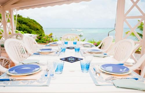 拉特里尼泰BRIN d AMOUR COTE ATLANTIQUE voir site vacances en martinique的蓝板和玻璃杯的白色桌子和海洋