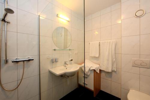 多恩比恩安德里斯河芬酒店的一间带水槽、淋浴和镜子的浴室