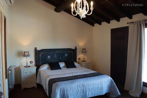 卡米诺新村Casa Rural La Cañada的一间卧室配有一张床和一个吊灯