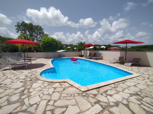 圣安尼Ti Village Creole的一个带遮阳伞的庭院内的游泳池