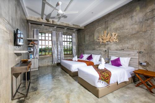 珍南海滩Tisha Langkawi Wellness Resort的带2扇窗户的客房内的2张床