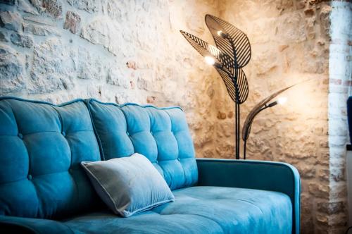 罗维尼Apartments Casa De Amicis的蓝色的沙发,配有枕头和灯