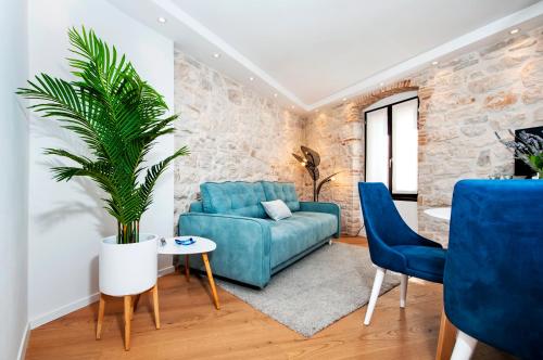 罗维尼Apartments Casa De Amicis的客厅配有蓝色沙发和植物