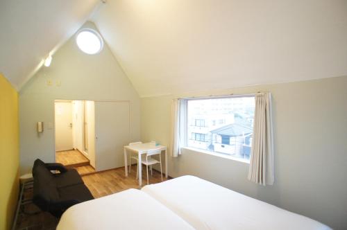 福冈Plusone Nishikoen的一间卧室设有两张床、一把椅子和一个窗户。