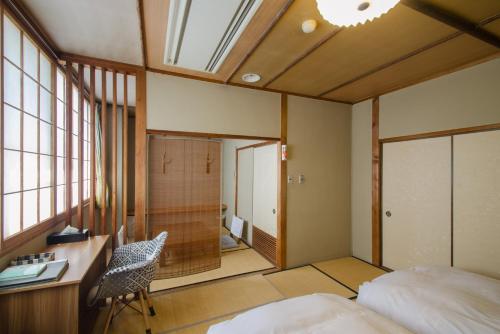 鸟羽凯格苏酒店的一间卧室配有一张床和一张桌子及椅子