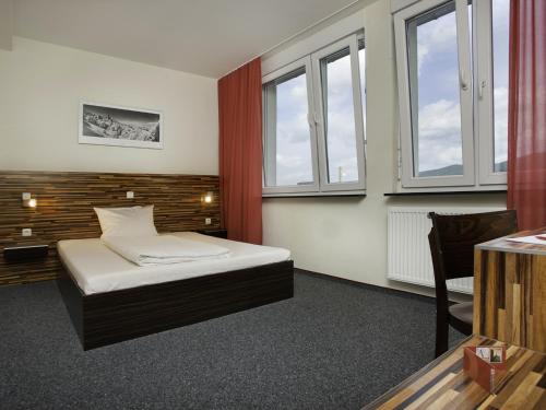 海德堡海德堡酒店的一间卧室设有一张床和两个窗户。
