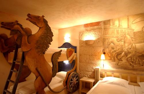 鲁斯特欧罗巴游乐园和厄尔布尼斯度假四星级高级酒店的卧室的墙上挂有木马壁画