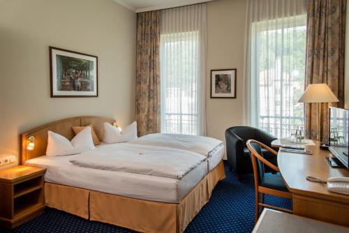 艾森纳赫葛洛肯霍夫酒店的配有一张床和一张书桌的酒店客房