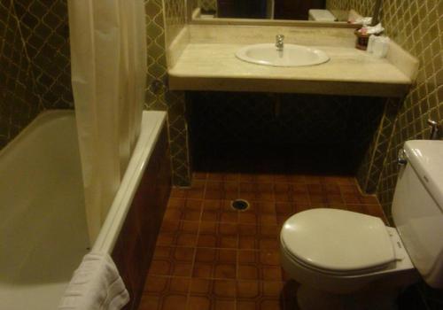曼谷苏达宫酒店的浴室配有卫生间、盥洗盆和浴缸。