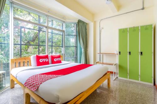 清迈OYO 928 Leaf Hostel的一间卧室配有一张大床和绿色储物柜