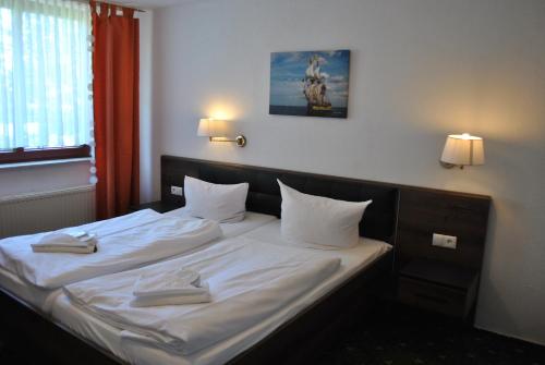 洛布洛贝斯特兰德酒店的一间卧室配有带白色床单和枕头的床。
