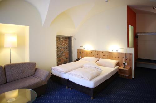 库尔Ambiente Hotel Freieck的一间卧室配有一张床、一把椅子和一张沙发