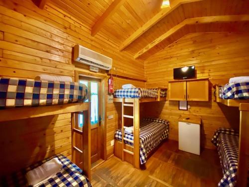 科托里奥斯亚诺斯德阿兰斯乡村营地旅馆的小屋内带三张双层床的客房