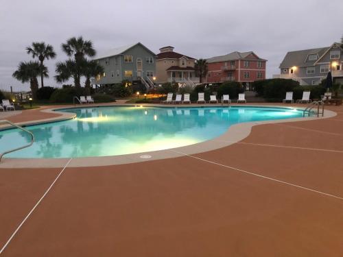 格尔夫海岸Gulf Shores Plantation的夜间游泳池,带椅子和房屋