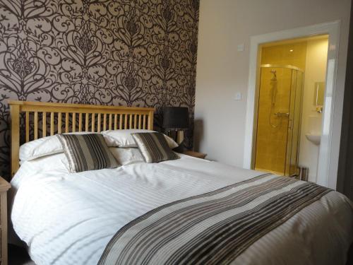 柯库布里Arden House Hotel的一间卧室配有一张带白色床单的大床