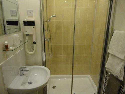 柯库布里Arden House Hotel的带淋浴、盥洗盆和淋浴的浴室