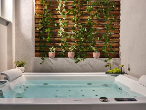 扎金索斯镇Pothos Suites的墙上的植物浴缸的浴室