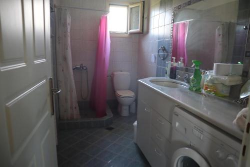 维瓦里MYRTO VIVARI的浴室设有水槽、卫生间和粉红色的淋浴帘