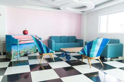 巴兰基亚Hotel Aquarius的客厅配有蓝色的沙发、桌子和椅子