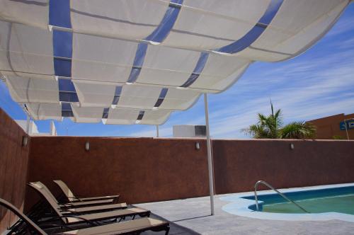 拉巴斯扎尔拉巴斯酒店的游泳池旁的天井配有椅子和遮阳伞。