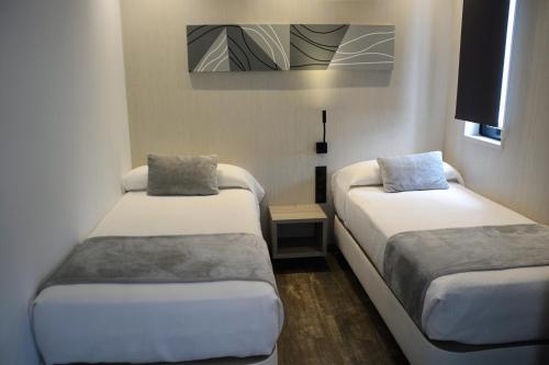 塞维利亚塞维利亚圣约斯塔旅舍 - 仅限成人入住 的小房间设有两张床和电视