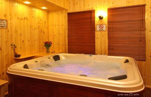 谢莫纳城Suites & Spa Galilee的木制浴室内设有大型白色浴缸。