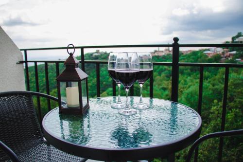 西格纳吉Villa Royal的阳台上的桌子上放了两杯葡萄酒