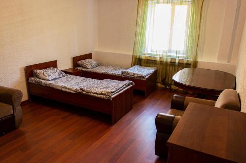 卡拉甘达Nuri Hotel Стадион的客厅设有两张床、一张桌子和一个窗户。