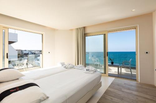 赫索尼索斯Kahlua Boutique Hotel的一间带两张床的卧室,享有海景