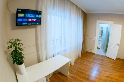 特鲁斯卡韦茨Embrace的客厅配有白色长凳和墙上的电视