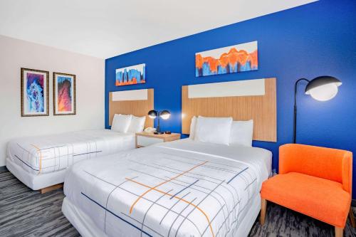 凯蒂La Quinta Inn & Suites Katy-Mills by Wyndham Katy的酒店客房,配有两张床和椅子