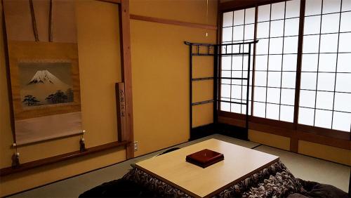 高山Hida House的窗户前设有桌子的房间