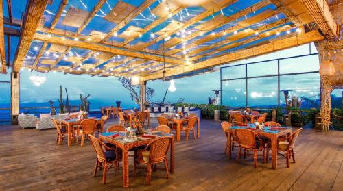 姆杜克Munduk Heaven Luxury Villas的一间带桌椅的海景餐厅