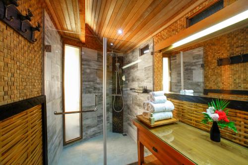 姆杜克Munduk Heaven Luxury Villas的带淋浴和毛巾水槽的浴室