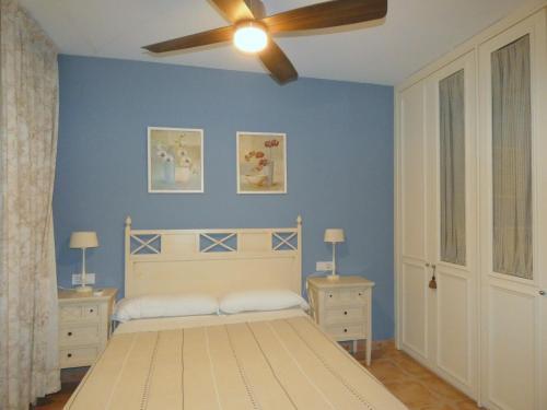 迈阿密普拉特亚Rentalmar Verdi Adosados的一间卧室配有一张床和吊扇