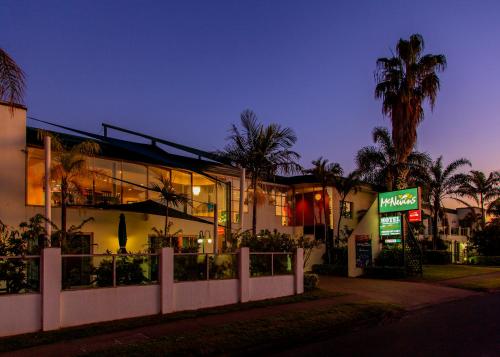 玛丽伯勒麦克尼汶斯玛丽伯勒汽车旅馆的一座有餐厅和棕榈树的建筑