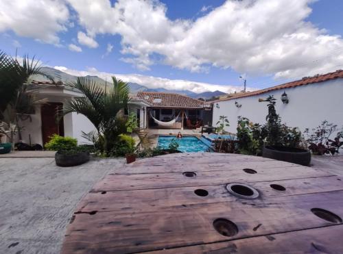 比尔卡班巴Hostel las Palmas的一个带木桌和游泳池的后院