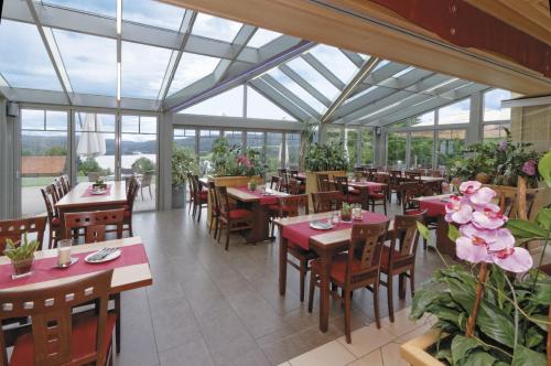 诺因布尔格福尔姆瓦尔德湖滨全景酒店的餐厅设有桌椅和窗户。