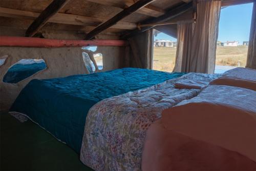 凯博波洛尼奥Lobo Hostel Bar的一间卧室设有两张床和窗户。
