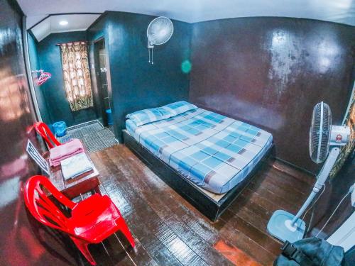 珍拉丁Maznah Guest House的一间卧室配有一张床、一张桌子和风扇