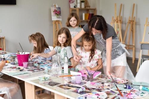 敖德萨Corner House的一群坐在桌子上制作工艺品的孩子