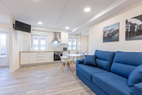 贝坦索斯MIRADOR DE LA MURALLA的一间带蓝色沙发的客厅和一间厨房